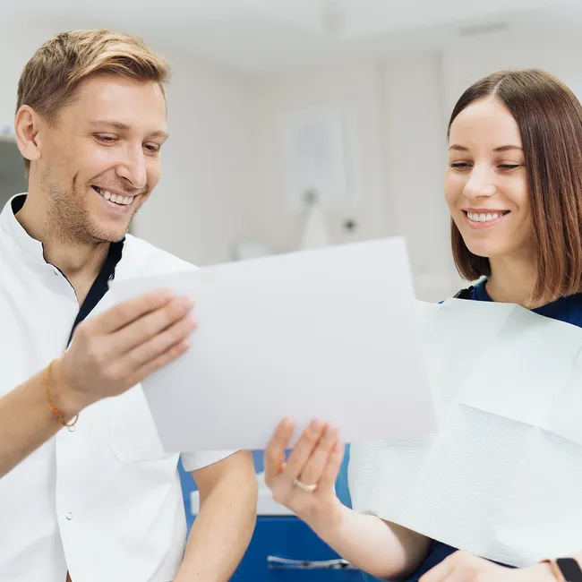 two people smiling holding paper
